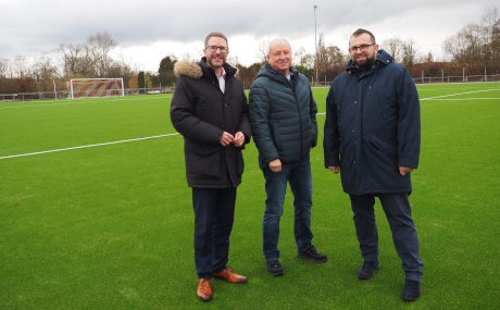 Landrat Thorsten Stolz, Joachim Lucas, Vorstandsmitglied des SV Altenmittlau 1912 e.V., und Freigerichts Bürgermeister Waldemar Gogel (von links) betrachten den neuen Kunstrasenplatz als Investition in die Zukunft. Der Main-Kinzig-Kreis hat im Rahmen der Sportförderung einen Zuschuss in Höhe von 75.000 Euro bereitgestellt.