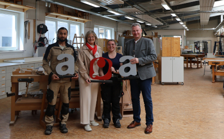 Blicken gemeinsam auf 35 Jahre erfolgreiche Tätigkeit der Gesellschaft für Arbeit, Qualifizierung und Ausbildung zurück: Erster Kreisbeigeordneter und AQA-Aufsichtsratsvorsitzender Andreas Hofmann und AQA-Geschäftsführerin Helmtrud Abs, hier in einer der AQA-Werkstätten gemeinsam mit zwei Auszubildenden für das Tischlerhandwerk, Bahram Hakimi und Natascha Kohler.