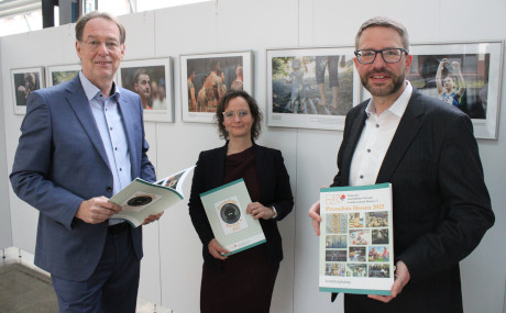 Axel Häsler, Vorsitzender des DJV-Bezirksverbands Hanau/Main-Kinzig, die Kreis-Kulturbeauftragte Sandra Li Männel und Landrat Thorsten Stolz (von links) haben die Fotoausstellung eröffnet, zu der auch eine Aufnahme vom Barfußpfad aus Bad Orb gehört (zweites Bild von rechts).