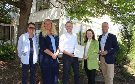 Kreisbeigeordneter Jannik Marquart (Mitte) und Landtagsabgeordneter Heiko Kasseckert überreichen den Förderbescheid für den zweiten Bauwagen an Bürgermeisterin Monika Böttcher (Zweite von rechts), Pia Funsch (Fachbereich Kinderbetreuung der Stadt Maintal, links) und Kita-Leiterin Simone Hahn-Beck.