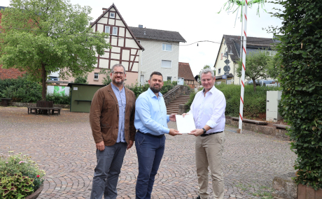 Bei der Übergabe des Förderbescheids aus Mitteln des hessischen Dorfentwicklungsprogramms (von links): Johannes Michel (Leiter der Abteilung Entwicklung ländlicher Raum beim Main-Kinzig-Kreis), Bürgermeister Thomas Henfling und Erster Kreisbeigeordneter Andreas Hofmann auf dem Dorfplatz in Altengronau, der attraktiver gestaltet wird.